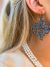 Handmade lace earrings displayed during model portrait
