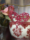 Handmade red lace heart shown among vintage décor.