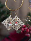 Christmas tatted diamond earrings photographed against a blurred holiday backdro