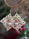 Tatted lace Christmas earrings hanging from a circular gold holder in a holiday