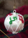Hand-tatted red, green, and white lace ornament on a satin Christmas ball