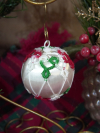 Hand-tatted red, green, and white lace ornament on a satin Christmas ball