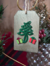 Handmade wooden ornaments featuring lace-tatted evergreen trees and gifts