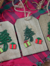 Three wooden tag ornaments with green tatted trees and tiny presents