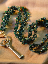 Dark green beaded tatted lanyard displayed neatly on cloth