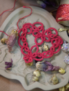 Romantic red lace heart ornament resting on decorative textures.