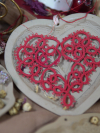 Large red tatted lace heart ornament displayed on ceramic heart tray.