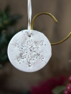 White clay ornament with silver glitter accents and a detailed lace snowflake te