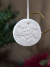 Round white ornament with iridescent multicolor glitter and a tatted lace snowfl