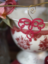 Red tatted lace heart suspended in front of vintage backdrop