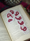 Red and white lace candy cane bookmark photographed on book pages with gentle Ch