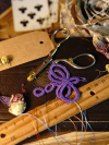 Purple tatted dragonfly displayed with craft scissors and petals