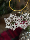 Three styles of silver tatted snowflake earrings in festive décor.