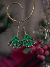 Festive tatted tree earrings displayed with holiday background