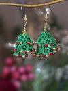 Hand-tatted green tree earrings shown in festive holiday décor