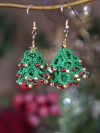 Lace Christmas tree earrings with red and gold beads hanging on hook