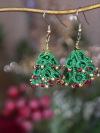 3D tatted green Christmas tree earrings with gold accents on display