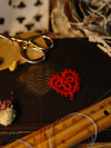 Tatted red heart displayed with dried petals and ruler
