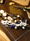 Close-up of white tatted keychain with lapis beads on old book