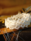 Classic open-pattern tatted lace displayed on old books and tools