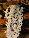 Dense white tatted lace with clustered rings on vintage books and ruler