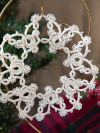 Large white tatted snowflake ornament hanging on gold stand