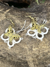 Twicewing earrings showing brass butterflies with tatted loops.