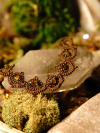 Close-up of brown lace bracelet with gold AB cube beads