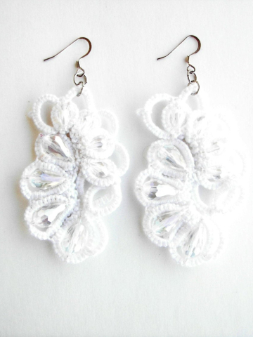 White tatted earrings with crystal drops on white backdrop
