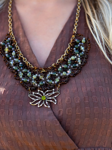 Brown lace necklace featuring green stones and crystal shimmer