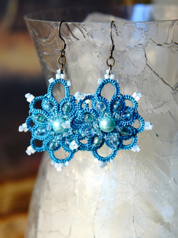 Close up of Duchess Drops Ankars earrings on glass vase.