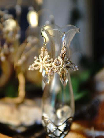 Champagne tatted earrings hanging in warm light