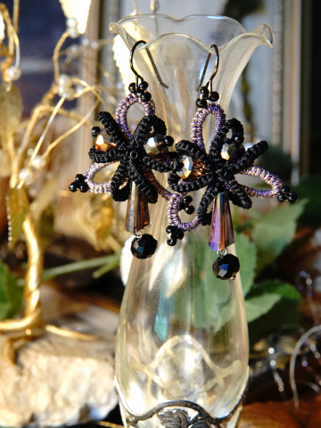 Obsidian Bloom earrings hanging from display vase