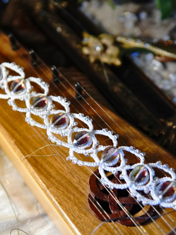 Whisperbind bracelet on wooden instrument