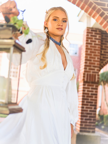 Model in white gown wearing Alaria outdoors