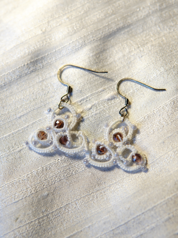 Earrings displayed on soft shimmering cloth.