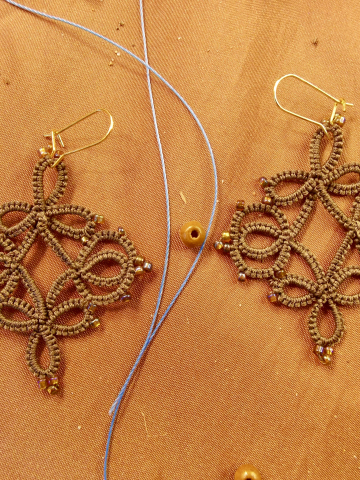 Close-up of threadwork and beads in a Wanderthread-style lace earring.
