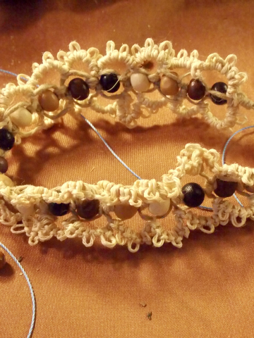 Side angle of Woodtrail bracelet showing bead placement and acorn clasp. Jute bracelet with wooden beads displayed on warm fabric.