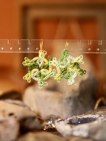Whirl earrings featuring airy lacework and picto details on rustic backdrop