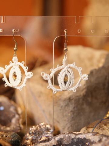 Tatted lace earrings shaped like eyes with golden glint