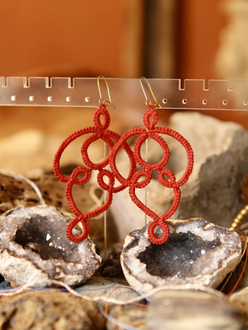 Red tatted lace earrings with looping arcs called Threaded Return.