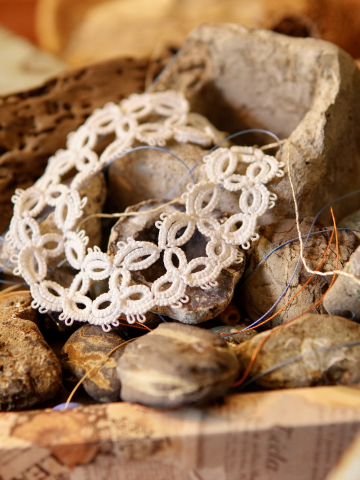 White tatted bracelet with airy lace loops displayed on a flat surface