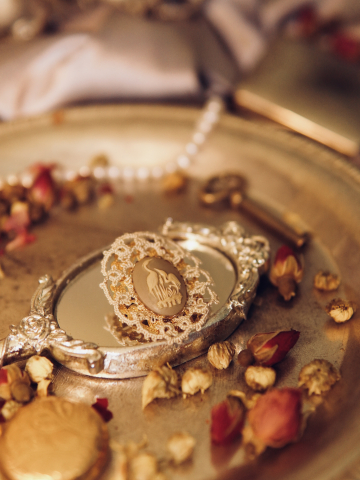 Ivory tatted lace heron cameo brooch on a silver mirror tray