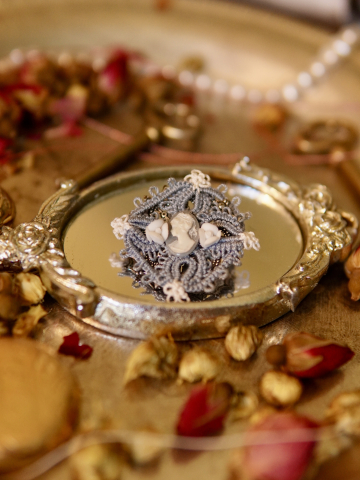 Hand-tatted blue lace cameo pin on vintage style background