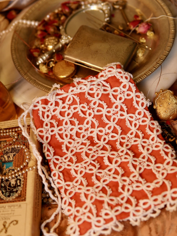 Close-up of lace detail over shimmering silk fabric.
