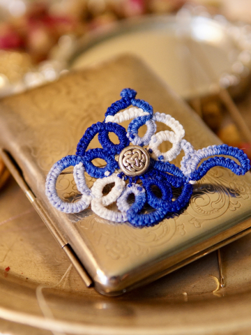 Blue-and-white lace teapot brooch in warm vintage light