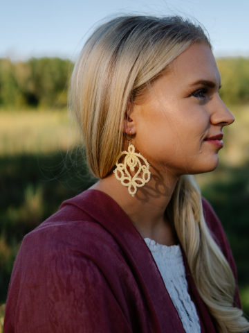 Woman wearing Lotusborne earrings in golden evening light