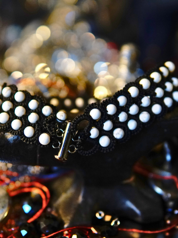 Close-up of black lace and white stone accents