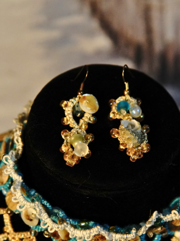 Close-up of Sandy Treasures earrings with ocean blue beads, pearls, and shells.