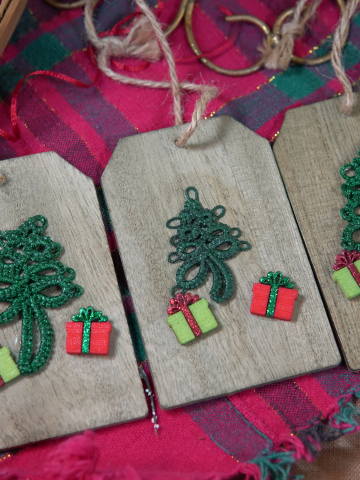 Three wooden tag ornaments with green tatted trees and tiny presents